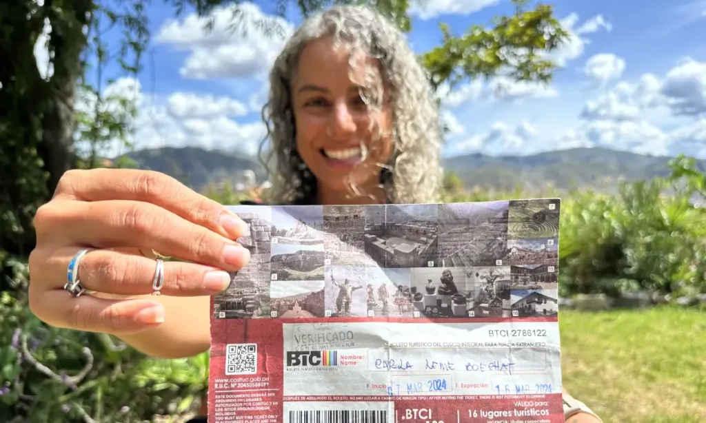 Turista latina exibindo seu bilhete turístico de Cusco